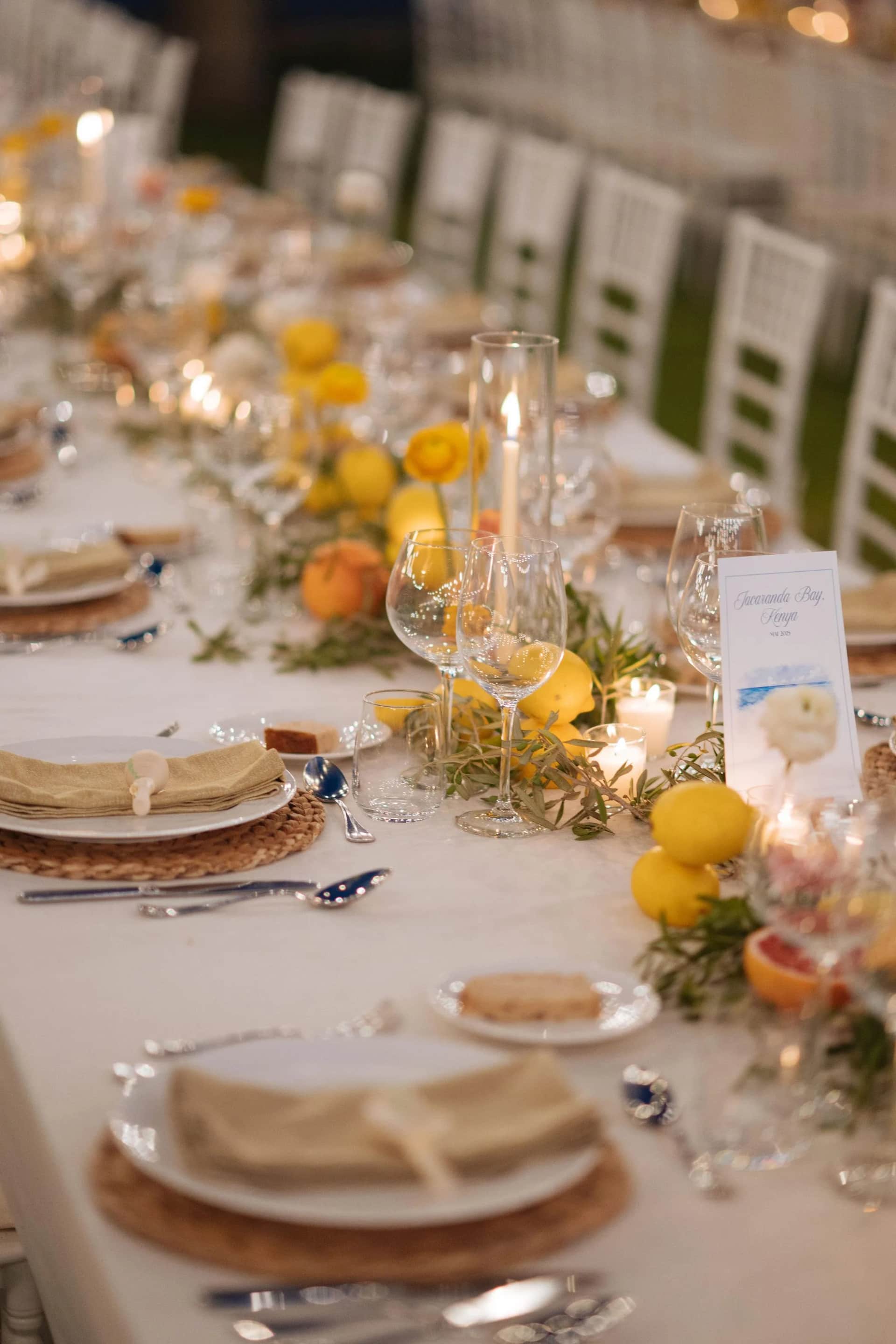 Dressage de table de mariage : sets tressés, assiettes, verrerie et bougies sur nappe blanche