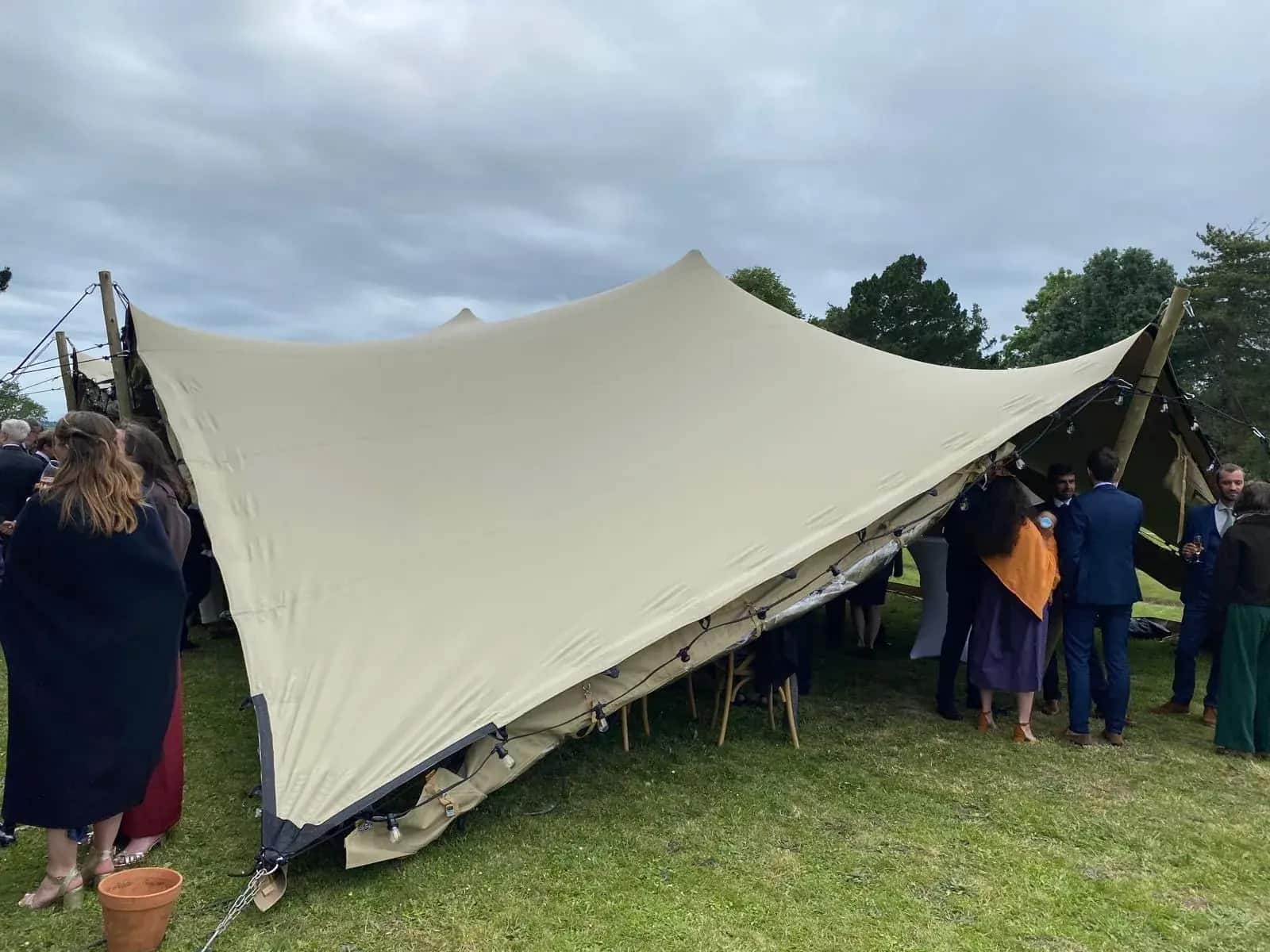 Cocktail de mariage sous stretch écrue — mâts bois, guirlandes guinguette