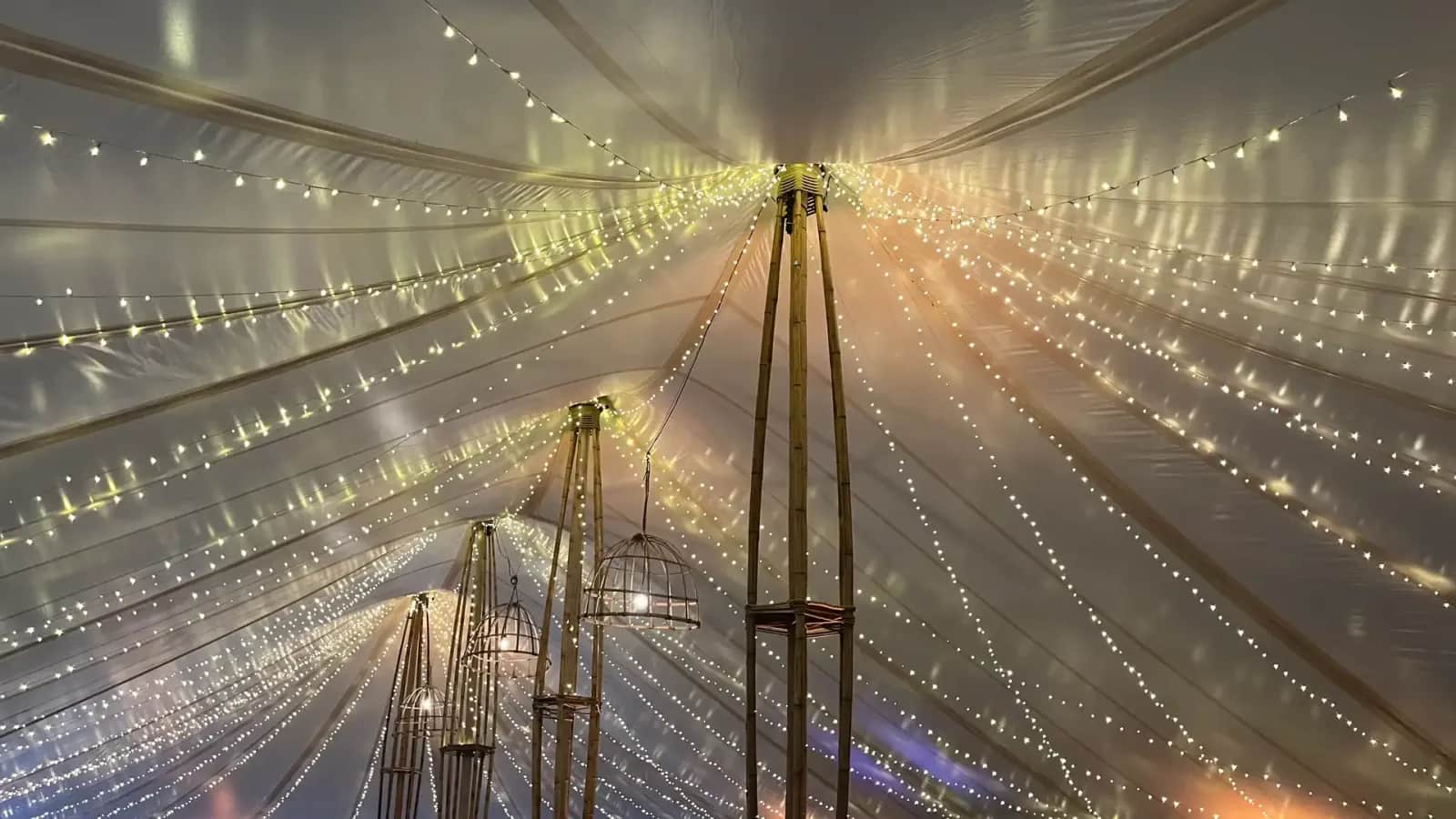 Ceiling of the bamboo marquee at night: fairy lights raining down like stars from the bamboo poles